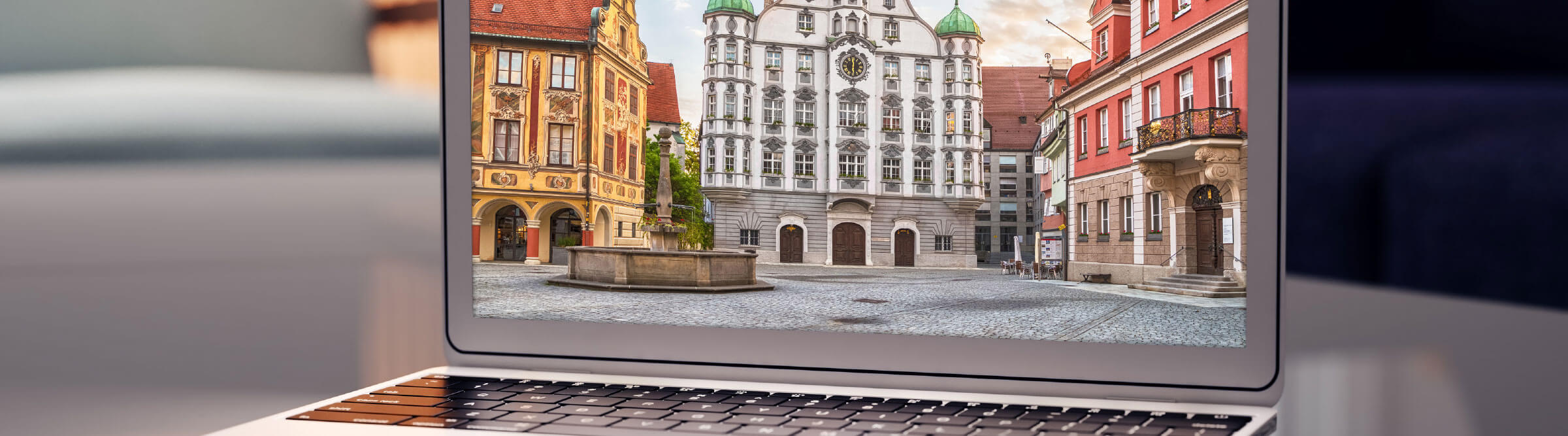 Header Bild von Memmingen auf einem Laptop, der auf einem dunklen Schreibtisch steht