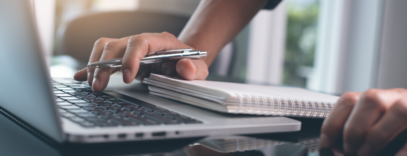 Person, die etwas in einen Laptop tippt, SEO-Texte, Suchmaschinenoptimiert
