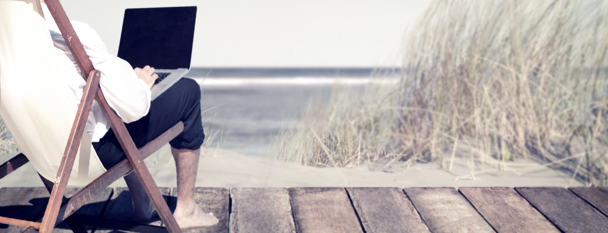 blog-header Mann sitzt auf Strandveranda mit laptop